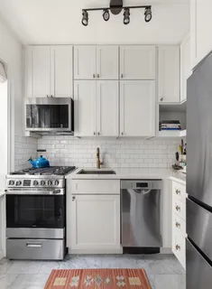 a kitchen with stainless steel appliances granite countertop a stove a microwave and a refrigerator