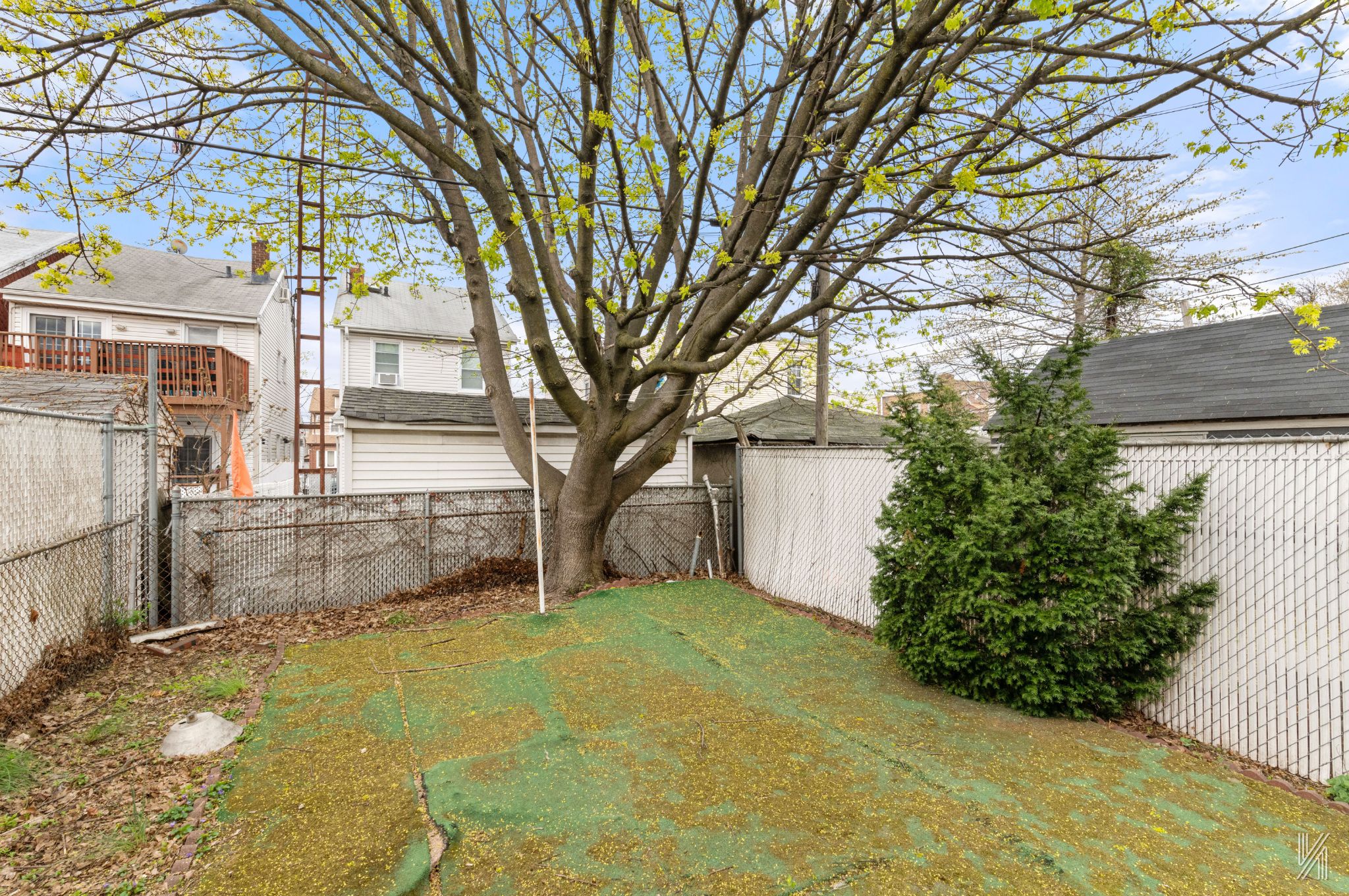 135-16 95th Street Queens, NY 11417 - Photo 18 of 21 a yellow house with trees in front of it