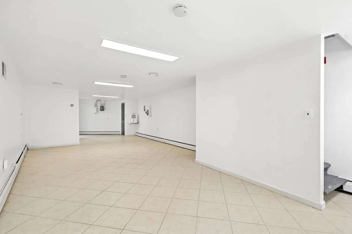 an empty room with white walls and tiles