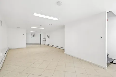 an empty room with white walls and tiles