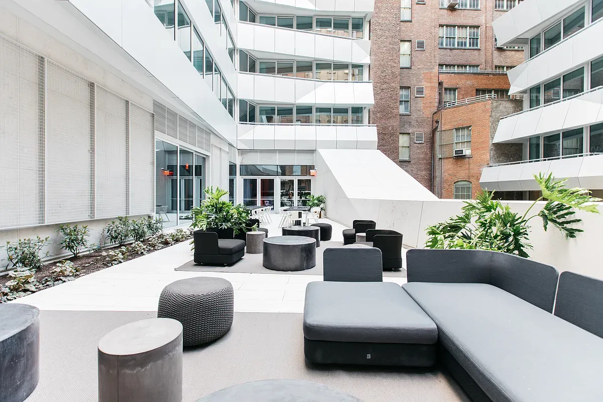 a view of a patio with couches table and chairs and potted plants