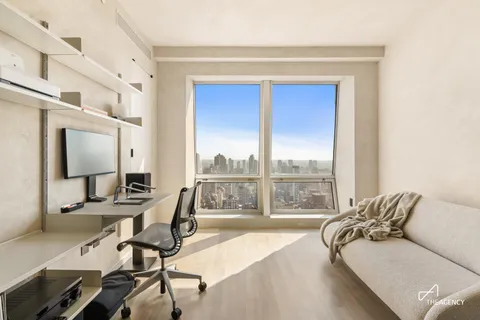 a view of a livingroom with workspace and a window