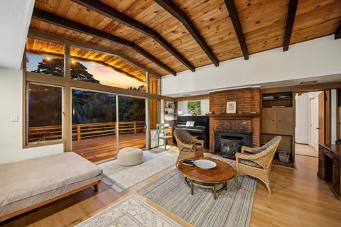 a view of a patio with table and chairs a barbeque with wooden floor and fence