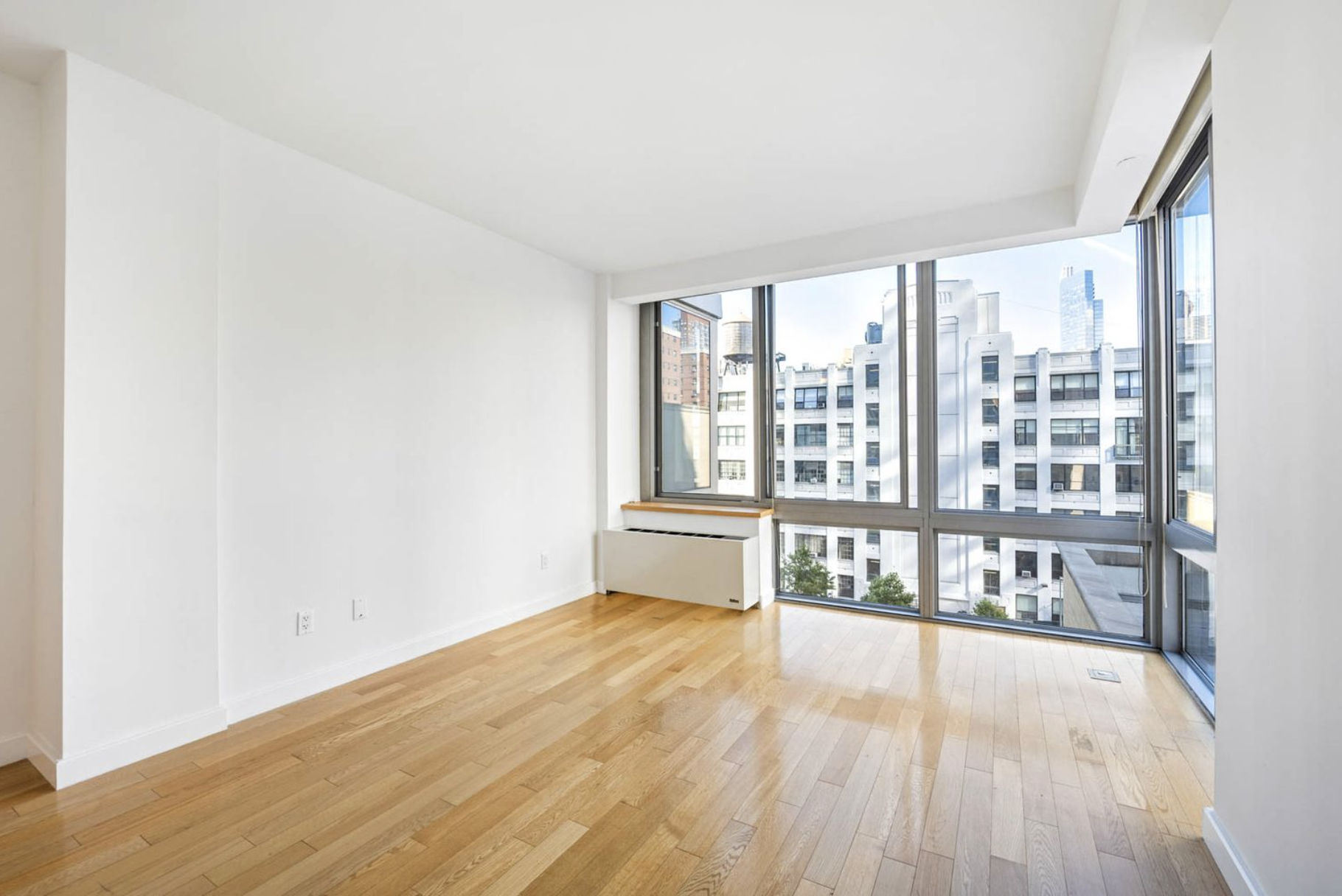 225 West 60th Street, Unit 8F Manhattan, NY 10023 - Photo 6 of 11 a big room with wooden floor and windows