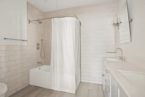 a bathroom with a bathtub and a sink a mirror