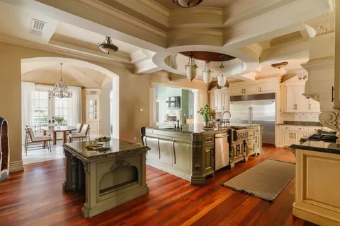 a living room with stainless steel appliances kitchen island granite countertop wooden floors and a view of living room
