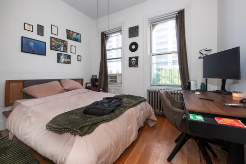 a bedroom with a bed window and a desk