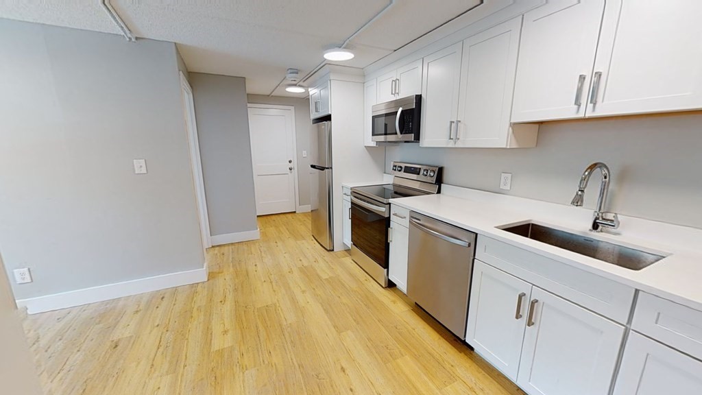 a kitchen with a sink a stove and cabinets