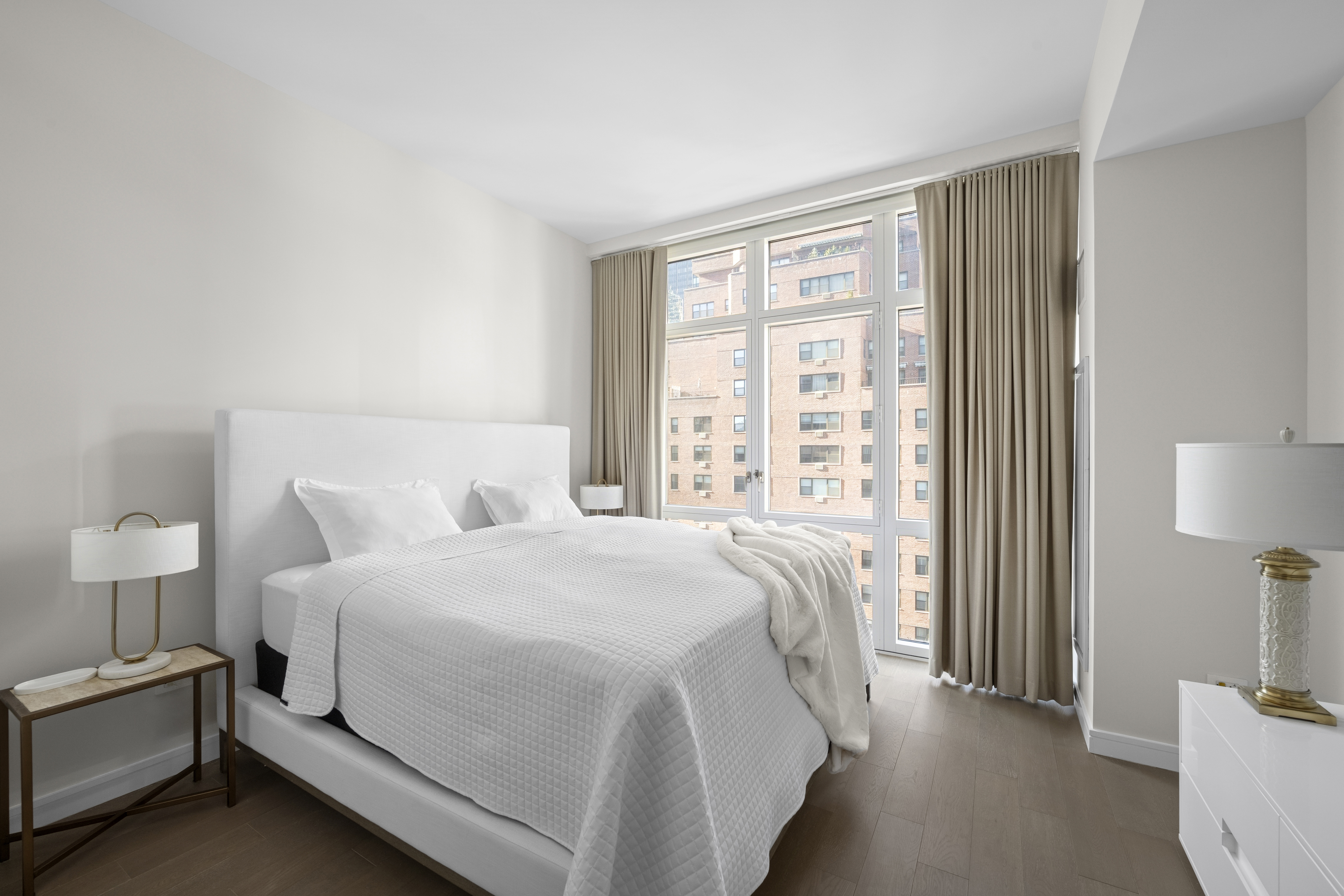 305 East 51st Street, Unit 11D Manhattan, NY 10022 - Photo 7 of 18 a bedroom with a bed and a lamp on table