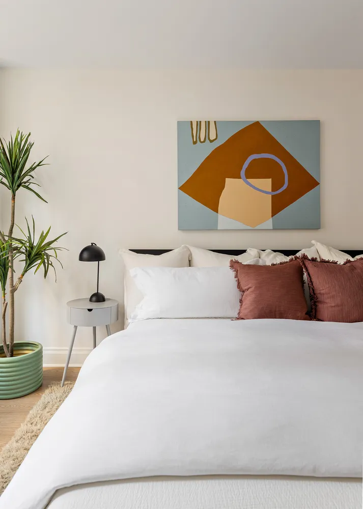 a bedroom with a bed and a potted plant