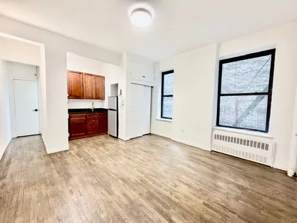 a view of an empty room with window and cabinet