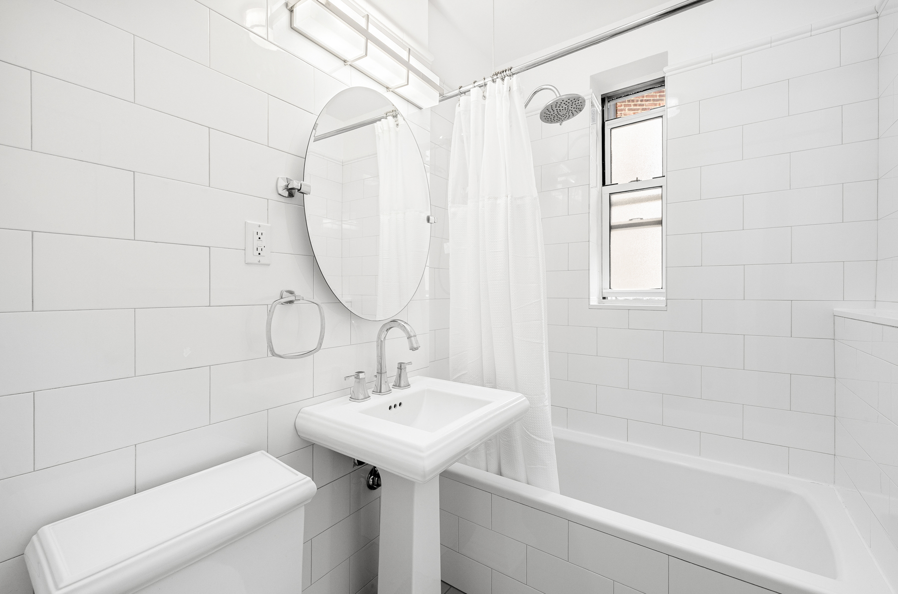 73-12 35th Avenue, Unit D56 Queens, NY 11372 - Photo 8 of 15 a bathroom with a sink a toilet and shower