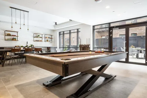 a living room with windows pool table and a large window