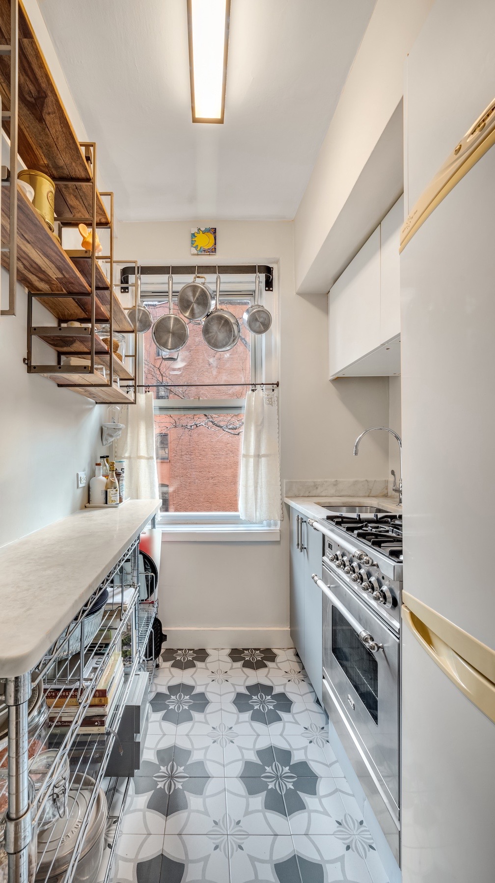 400 East 59th Street, Unit 3G Manhattan, NY 10022 - Photo 4 of 7 a kitchen with a stove a sink and a refrigerator