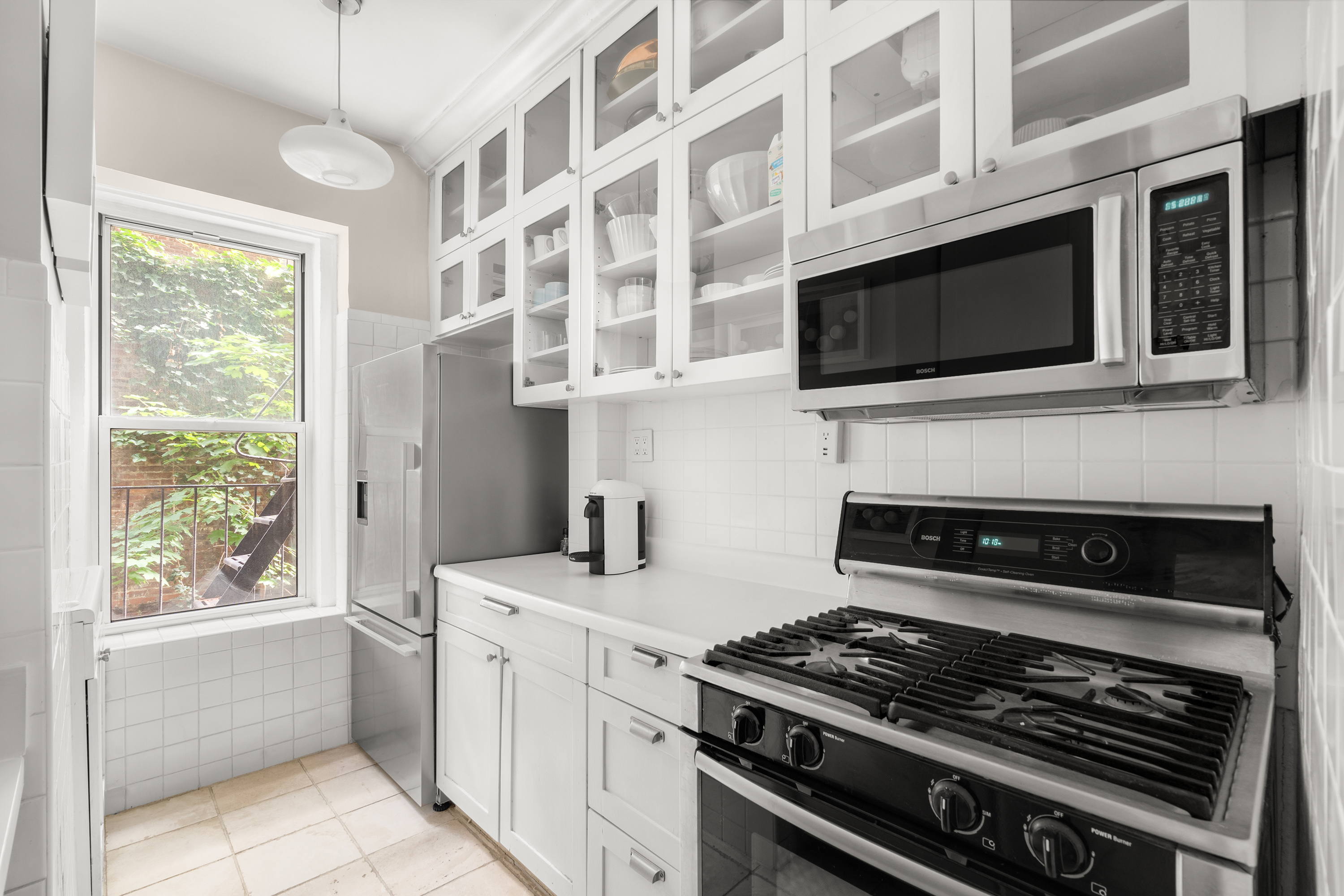 261 West 22nd Street, Unit 4 Manhattan, NY 10011 - Photo 5 of 8 a kitchen with stainless steel appliances a stove and a microwave