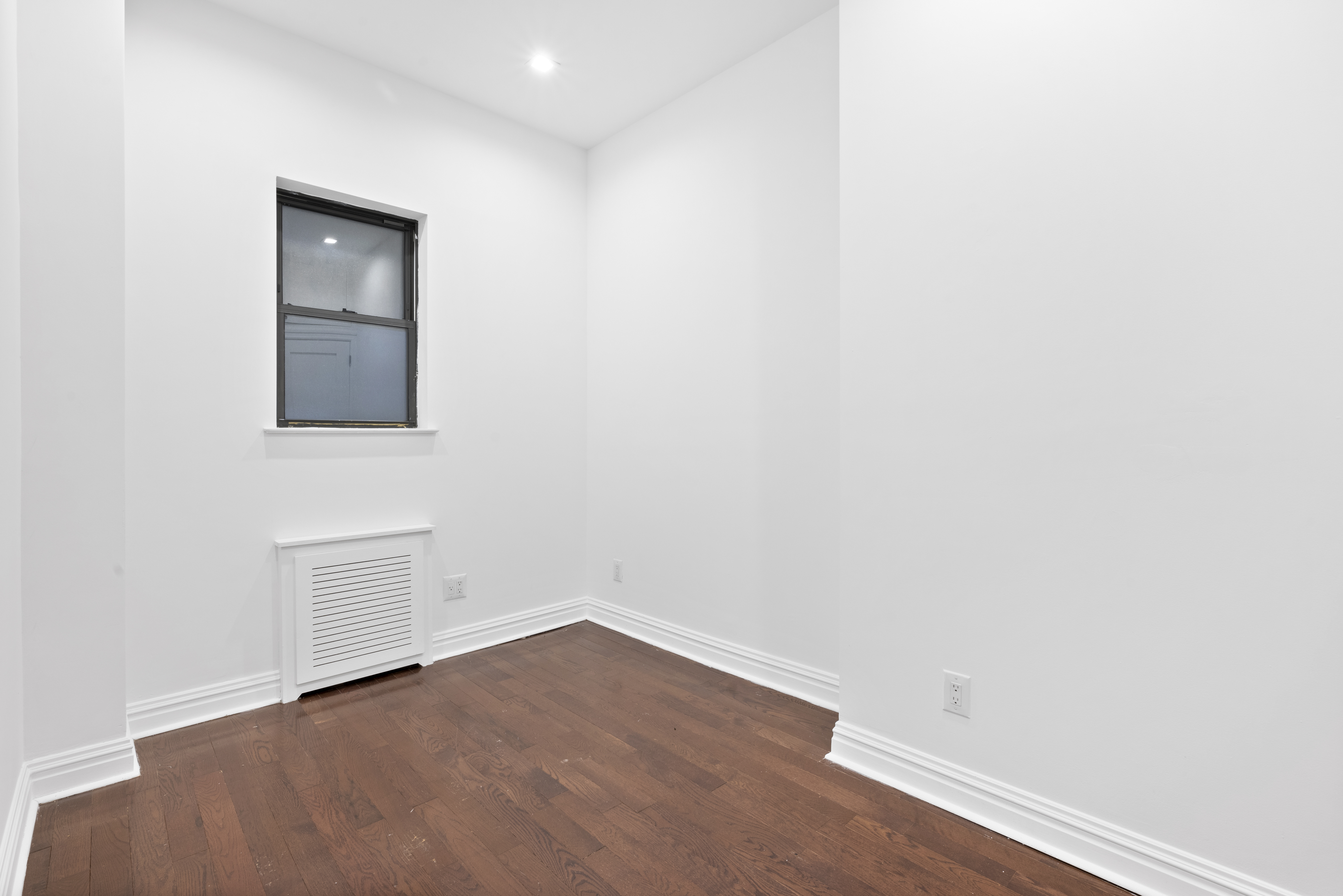 31 St Marks Place, Unit 4 Manhattan, NY 10003 - Photo 4 of 11 a view of an empty room with wooden floor and a window