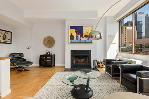 a living room with furniture a fireplace and a large window