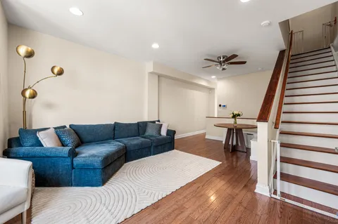 a living room with furniture and a wooden floor