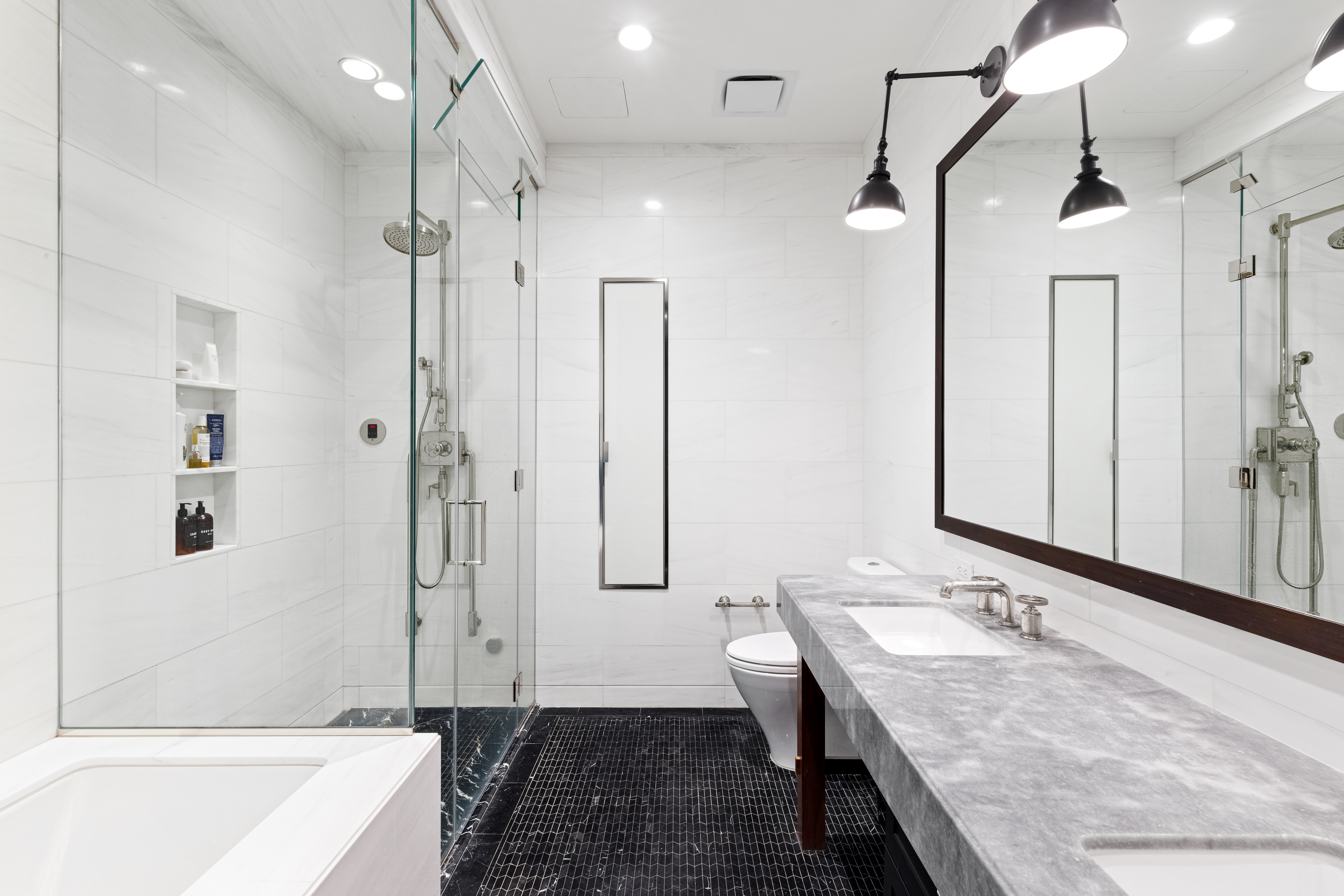 425 West 50th Street, Unit 15G Manhattan, NY 10019 - Photo 7 of 14 a bathroom with a granite countertop sink a toilet a mirror and shower