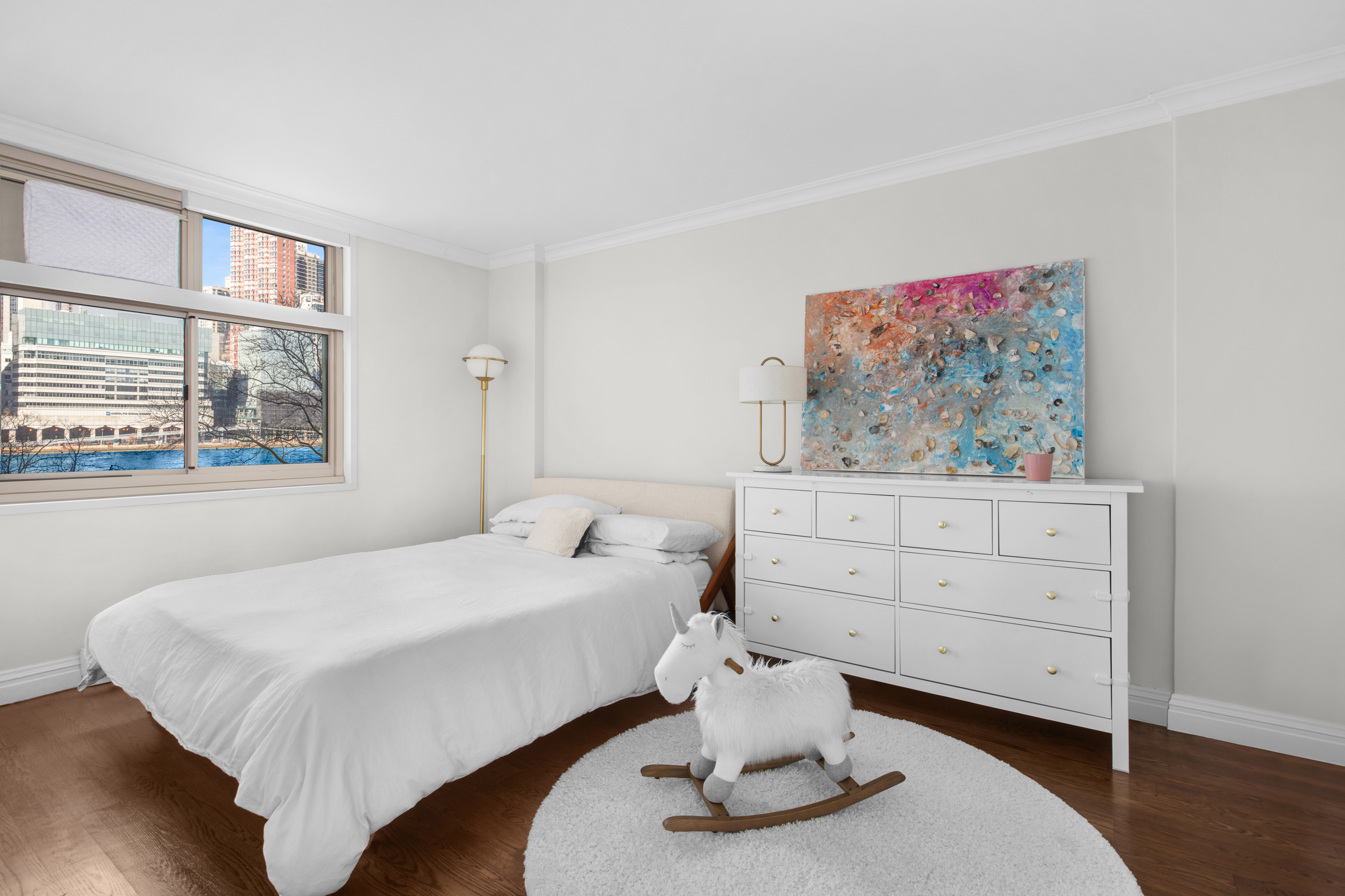 575 Main Street, Unit 509 Manhattan, NY 10044 - Photo 9 of 25 a bedroom with a bed and wooden floor