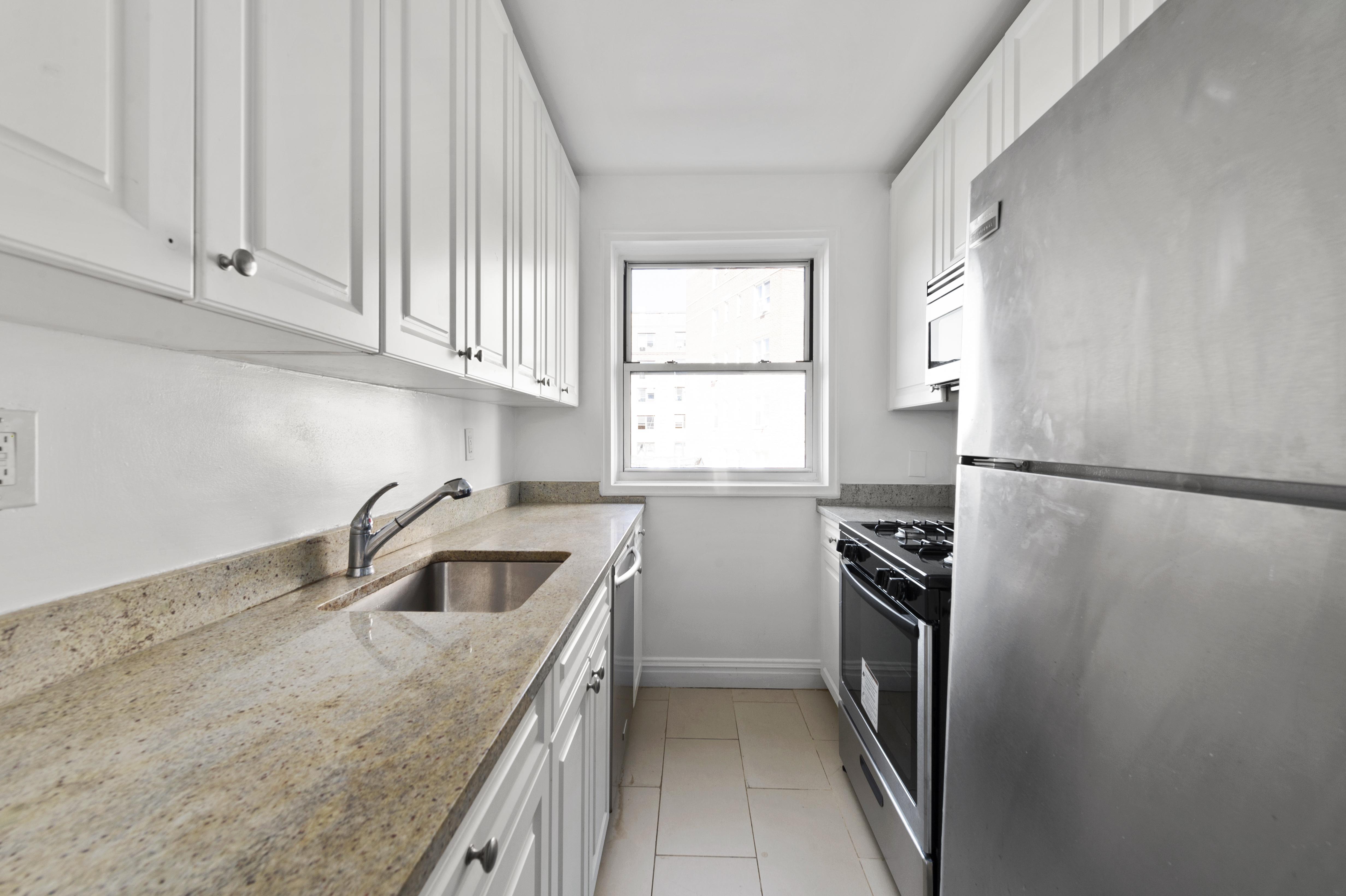 105-05 69th Avenue, Unit 301 Queens, NY 11375 - Photo 5 of 13 a kitchen with a refrigerator sink and cabinets