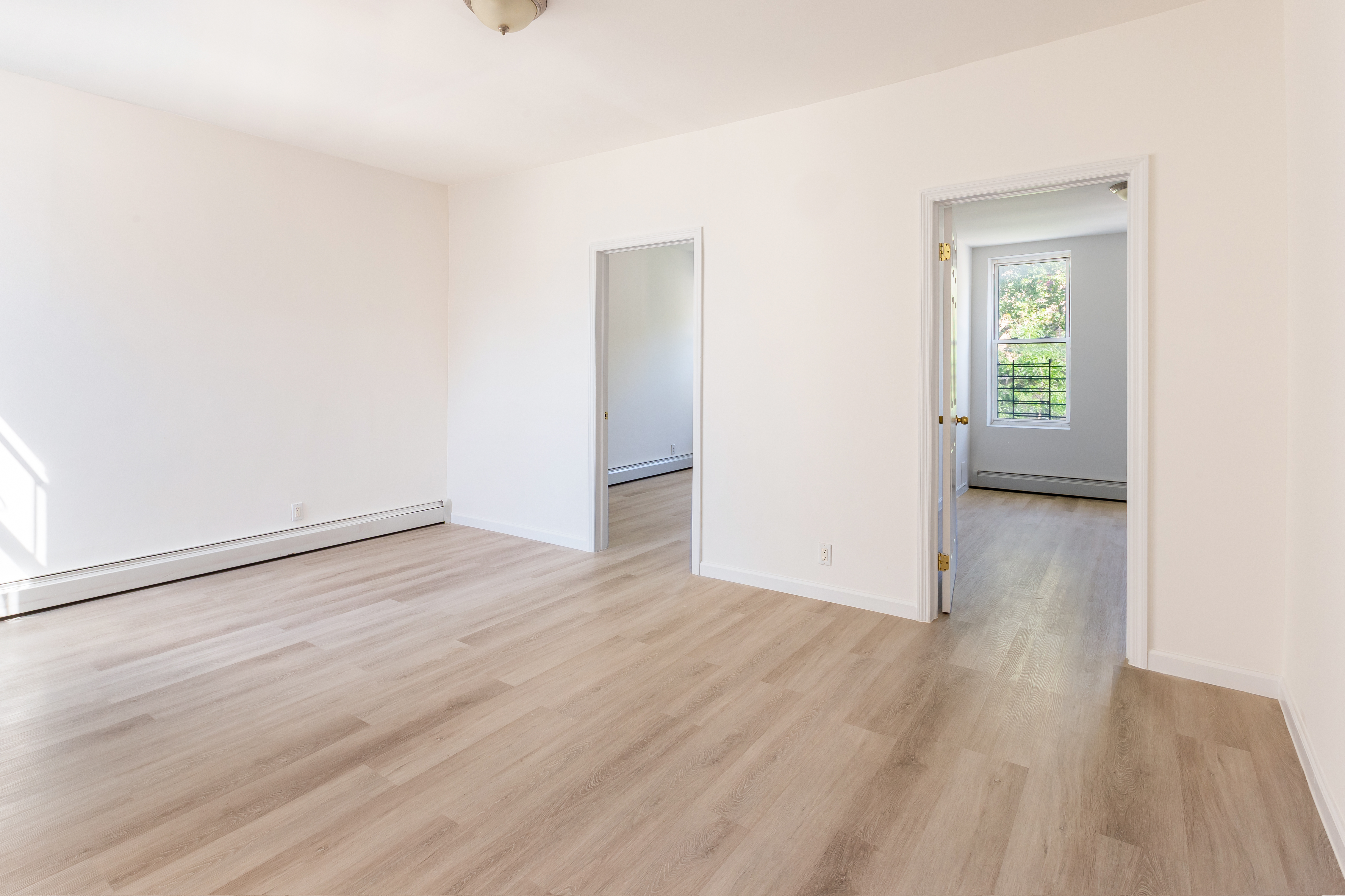 1030 Winthrop Street, Unit 2A Brooklyn, NY 11212 - Photo 4 of 10 an empty room with wooden floor and windows
