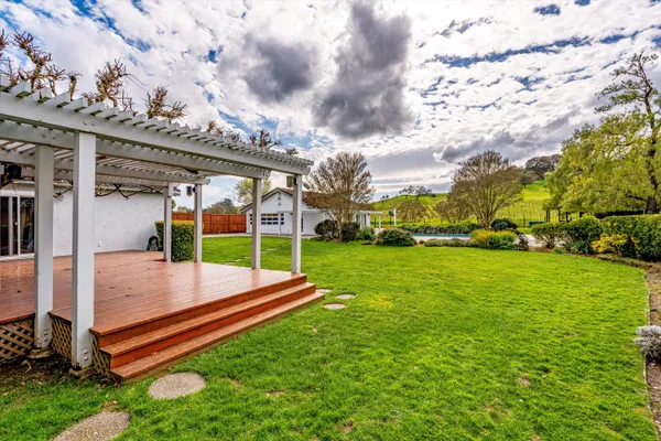 a view of a backyard with lawn chairs and iron fence