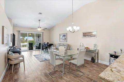 a view of a dining room with furniture a chandelier and wooden floor