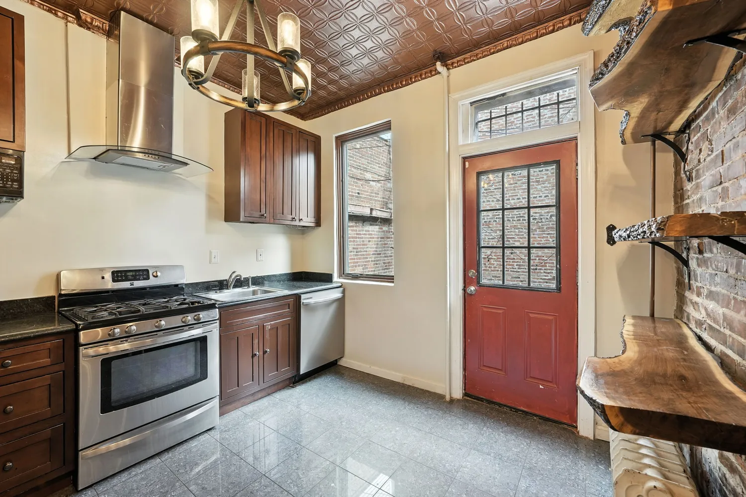 a kitchen with stainless steel appliances granite countertop a stove a sink and a refrigerator
