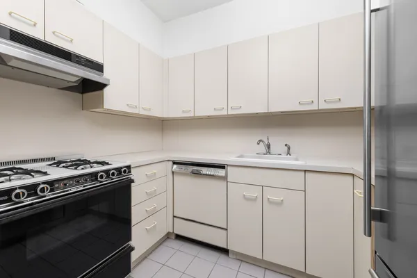 a kitchen with white cabinets and sink