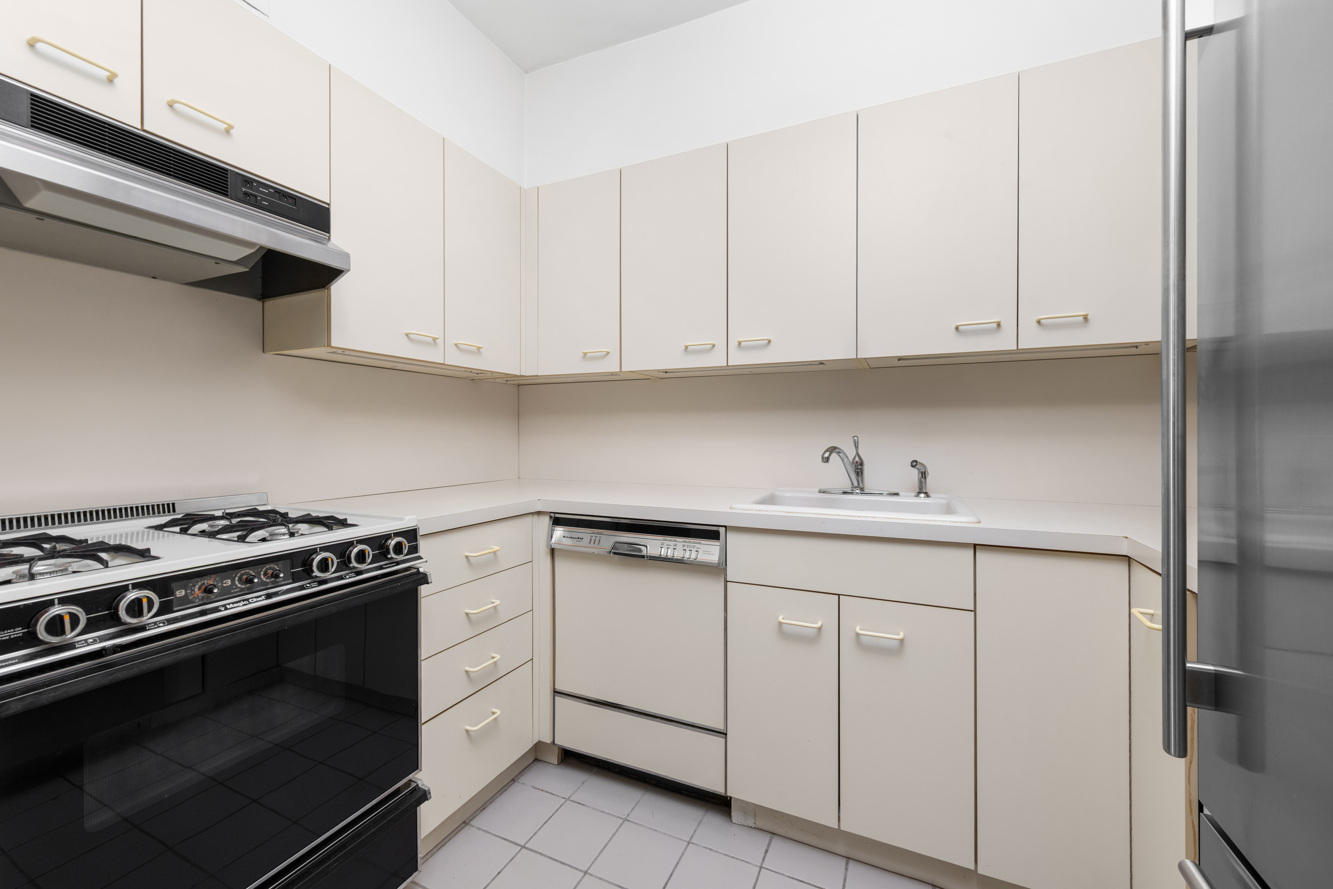 25 Sutton Place South, Unit 4I Manhattan, NY 10022 - Photo 5 of 16 a kitchen with white cabinets and sink