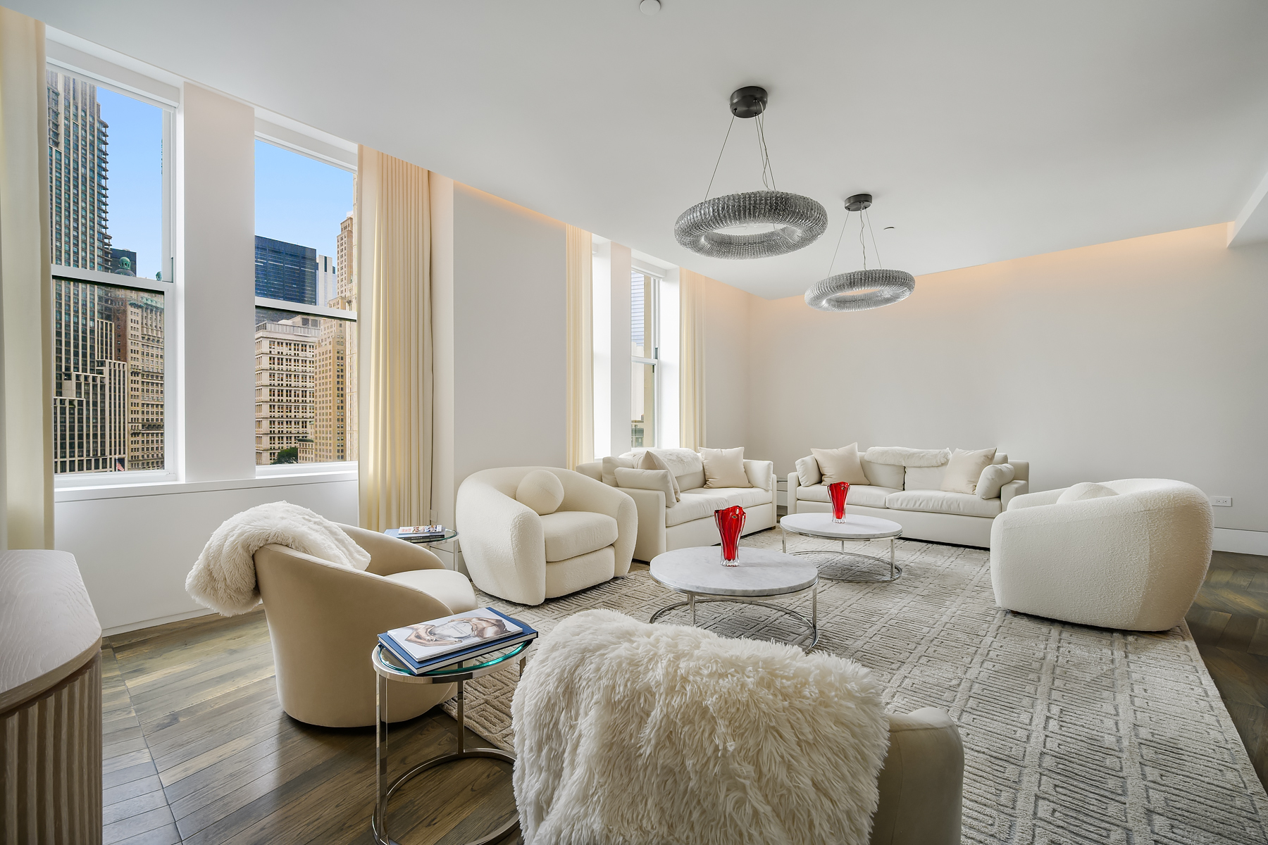 a living room with furniture and two large window