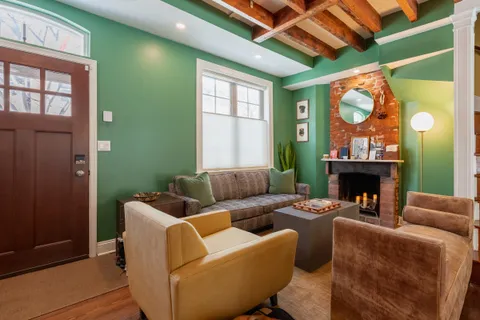 a living room with furniture a fireplace and a window