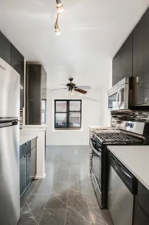 a kitchen with stainless steel appliances granite countertop a stove a sink and a refrigerator
