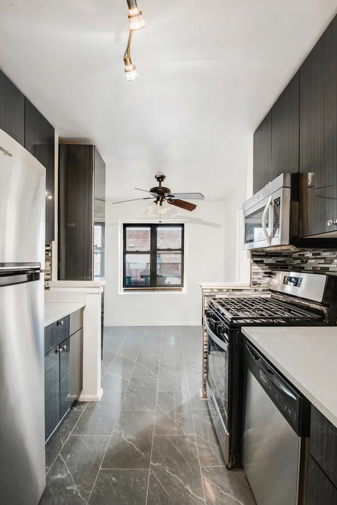 a kitchen with stainless steel appliances granite countertop a stove a sink and a refrigerator