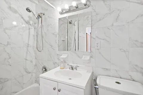 a bathroom with a sink a toilet and shower