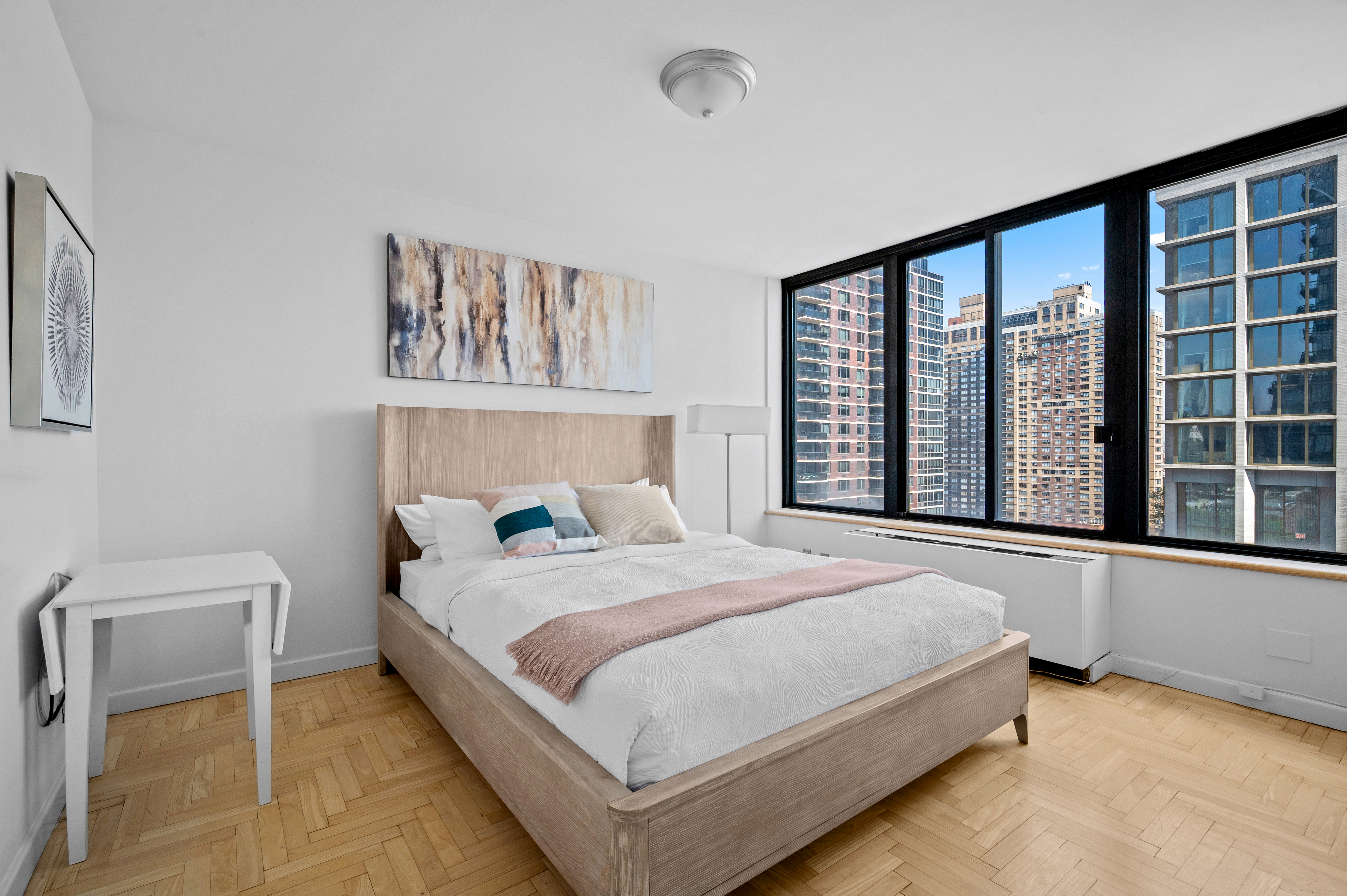 300 East 93rd Street, Unit 21C Manhattan, NY 10128 - Photo 4 of 6 a bedroom with a large bed and a large window