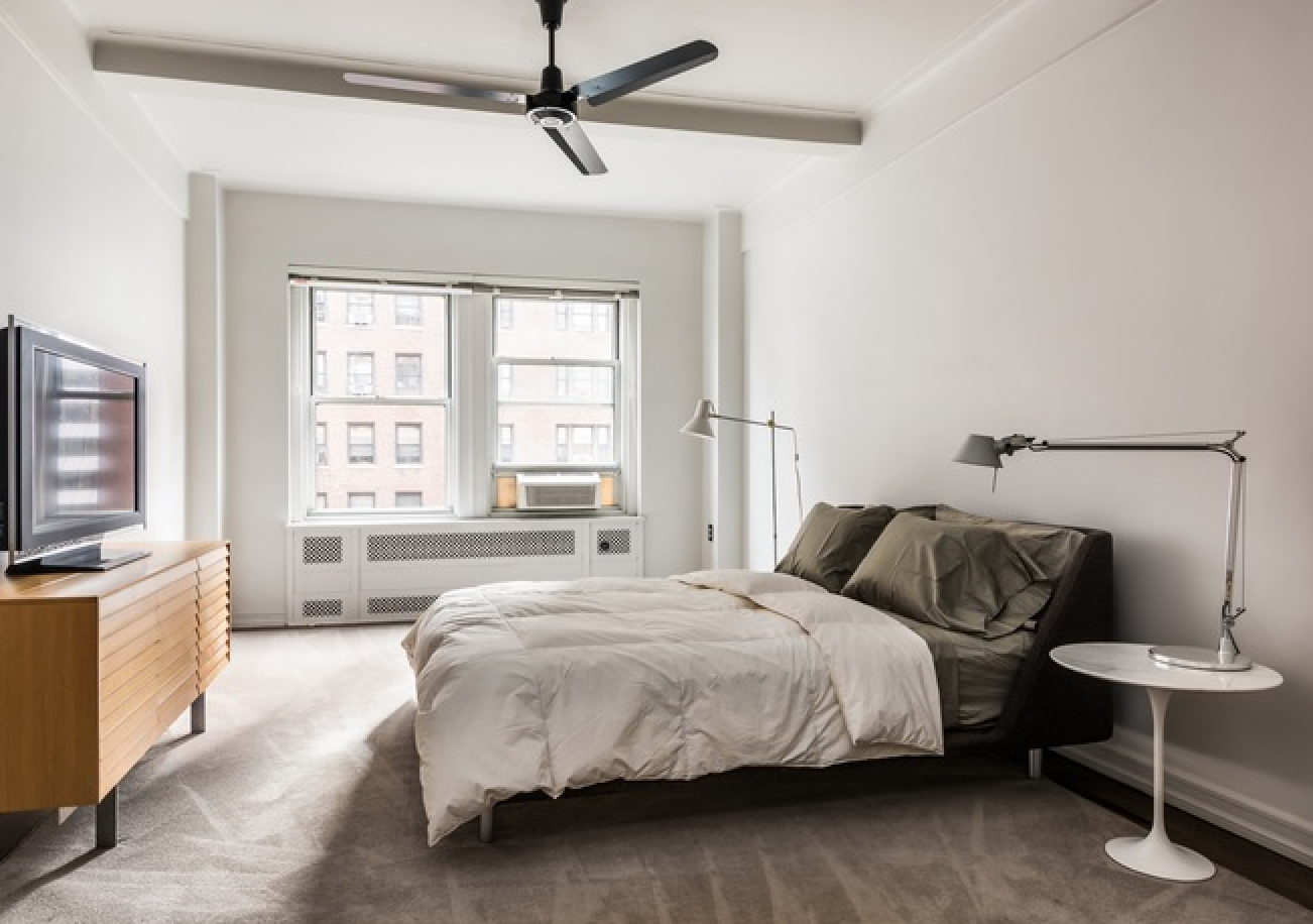 433 West 34th Street, Unit 9E Manhattan, NY 10001 - Photo 3 of 10 a bedroom with a bed a chandelier and a couch