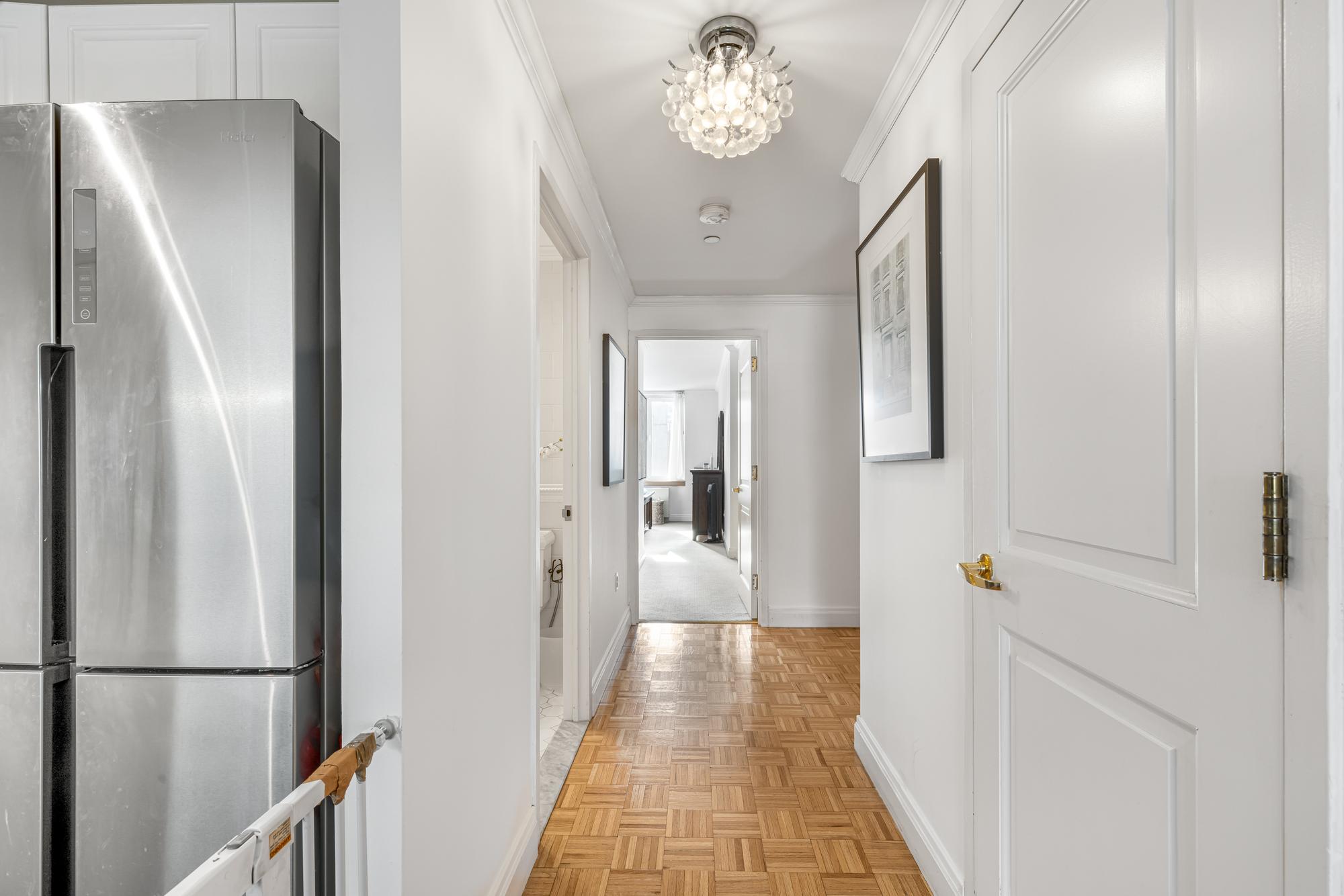 404 East 76th Street, Unit 6K Manhattan, NY 10021 - Photo 11 of 12 a view of a hallway with wooden floor and staircase