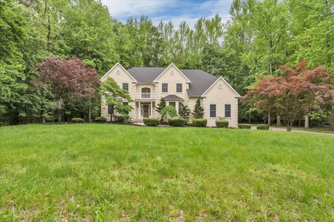 a front view of a house with a yard and trees