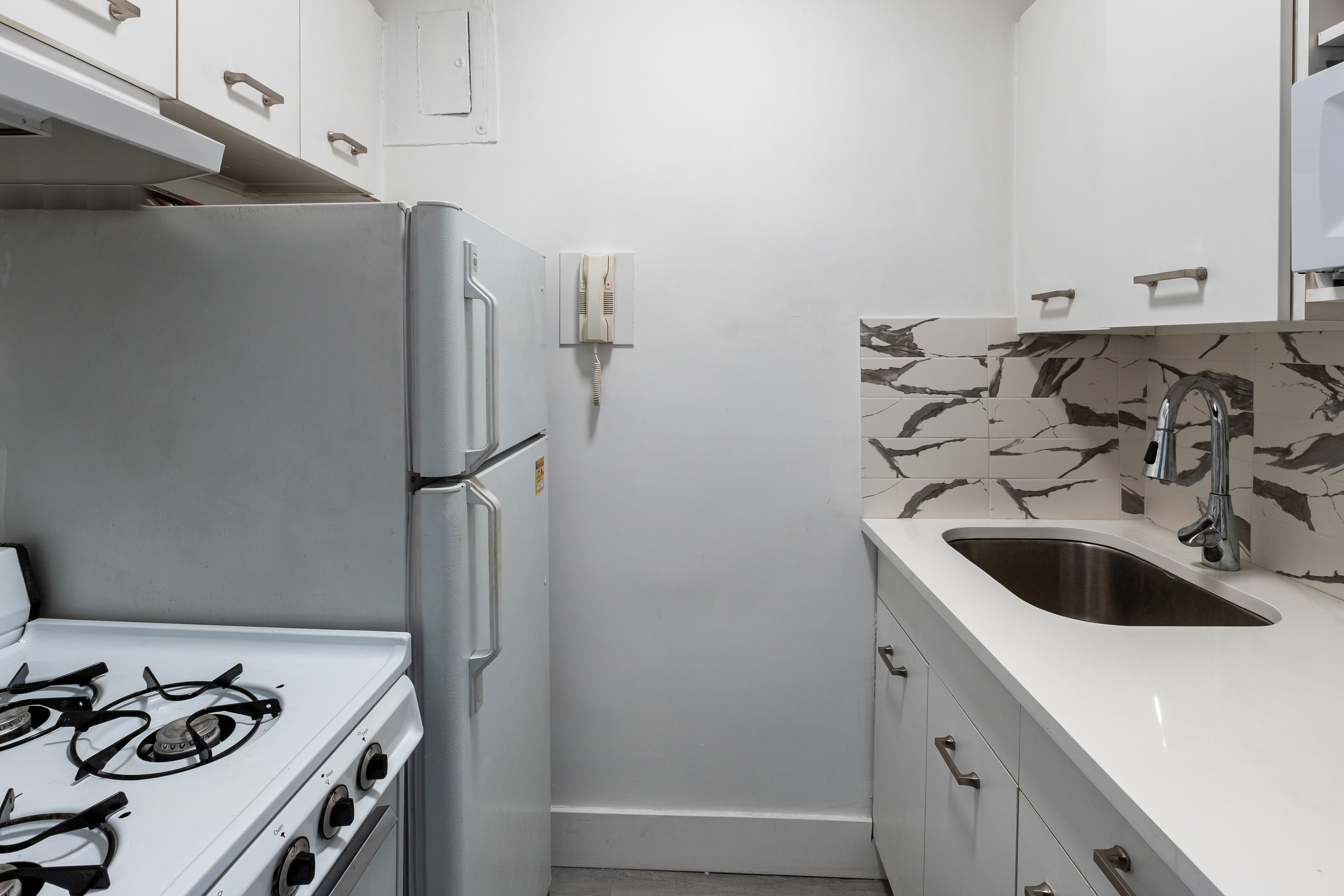 166 East 35th Street, Unit 12C Manhattan, NY 10016 - Photo 4 of 8 a kitchen with a sink and a refrigerator