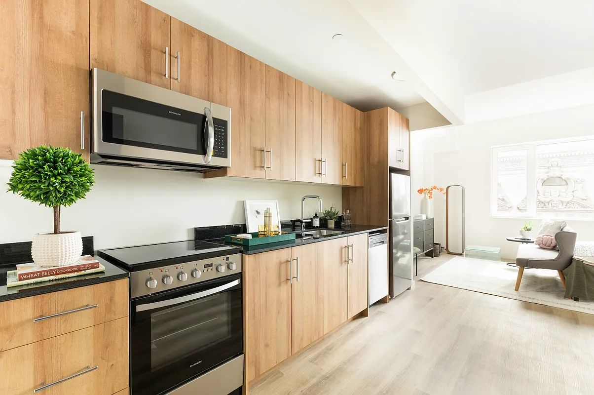 8 Palmetto Street, Unit 608 Brooklyn, NY 11221 - Photo 1 of 12 a kitchen with stainless steel appliances kitchen island granite countertop a stove a sink and a microwave