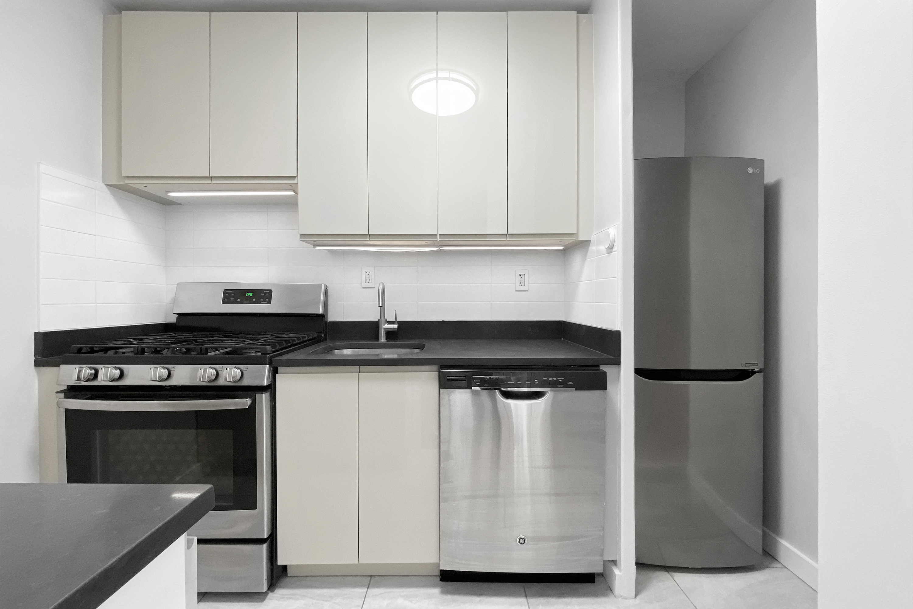 330 East 33rd Street, Unit 3F Manhattan, NY 10016 - Photo 4 of 15 a kitchen with stainless steel appliances granite countertop a refrigerator and a stove
