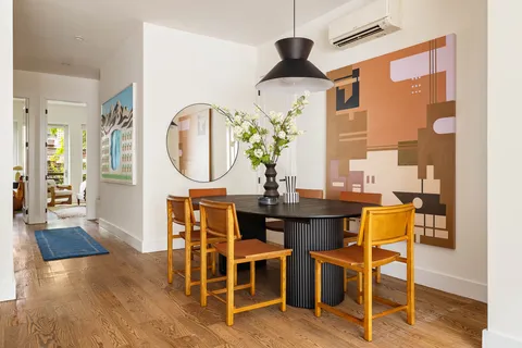 a view of a dining room with furniture a chandelier and wooden floor