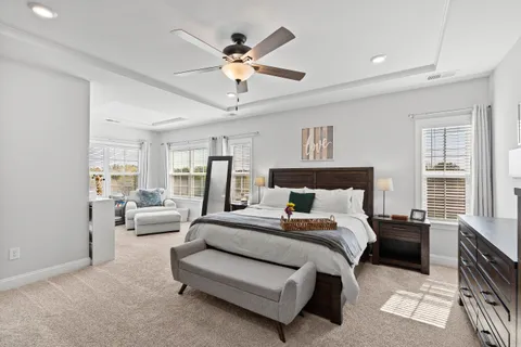 a spacious bedroom with a bed couch and a window