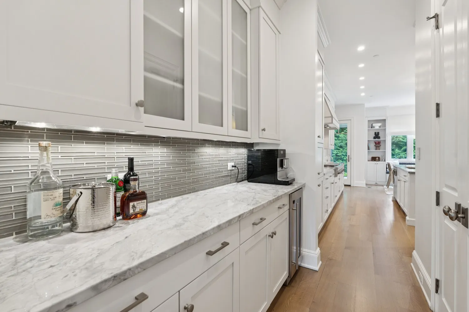 a kitchen with stainless steel appliances granite countertop a kitchen island a stove a sink a dining table and chairs with wooden floor