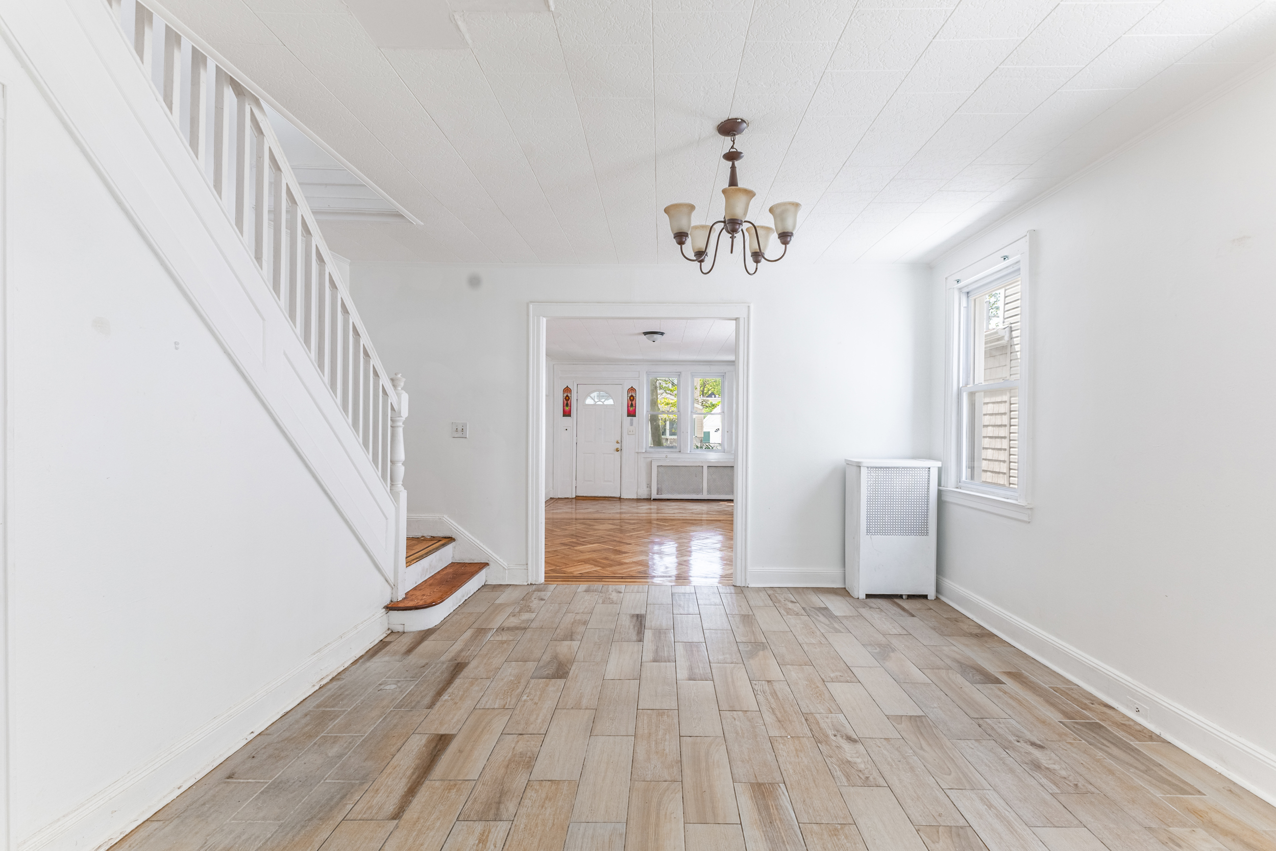 69-29 67th Place Queens, NY 11385 - Photo 9 of 24 a view of a hallway view with wooden floor and staircase