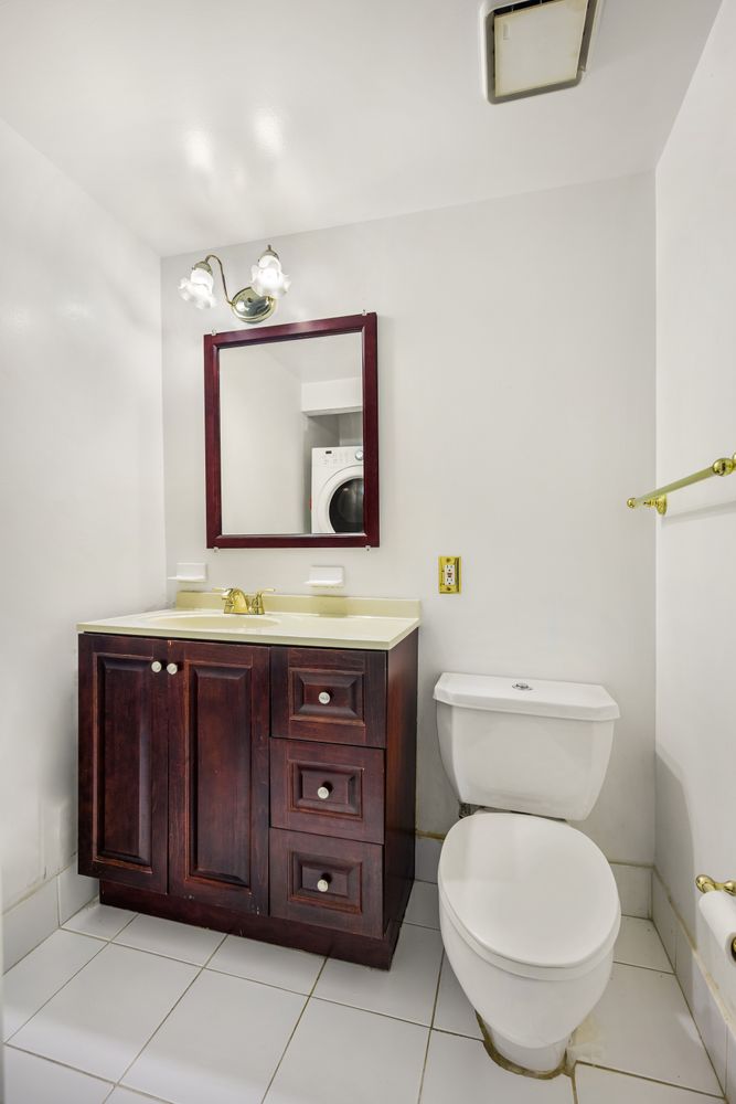 2560 Frederick Douglass Boulevard, Unit D Manhattan, NY 10030 - Photo 10 of 12 a bathroom with a toilet a sink and mirror