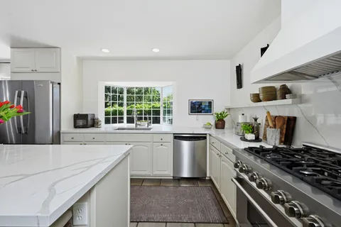 a kitchen with stainless steel appliances a sink stove and refrigerator