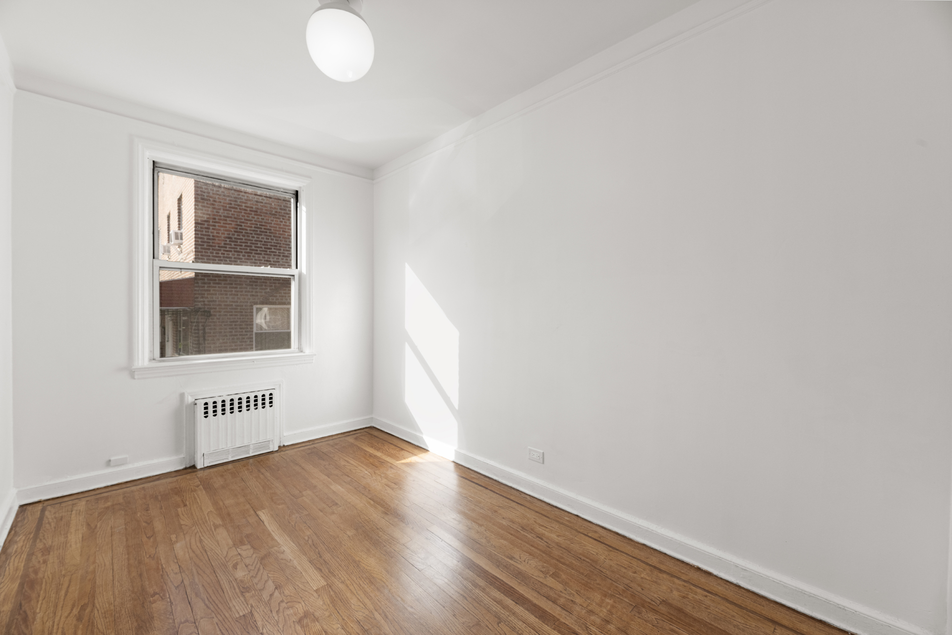 3883 Cannon Place, Unit 3 Bronx, NY 10463 - Photo 4 of 12 an empty room with wooden floor and windows